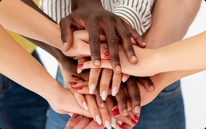 Diverse group of hands stacked together in unity